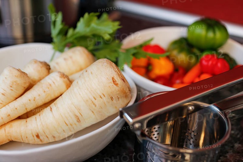 Swabian cuisine, raw parsley root for the preparation of parsley root and mashed potatoes for sour kidneys, grandmother's kitchen, regional, ingredients, healthy, vegetables, tomatoes in front, potato press, home cooking, typical Swabian, traditional cuisine reinterpreted, food photography, studio, Germany, Europe