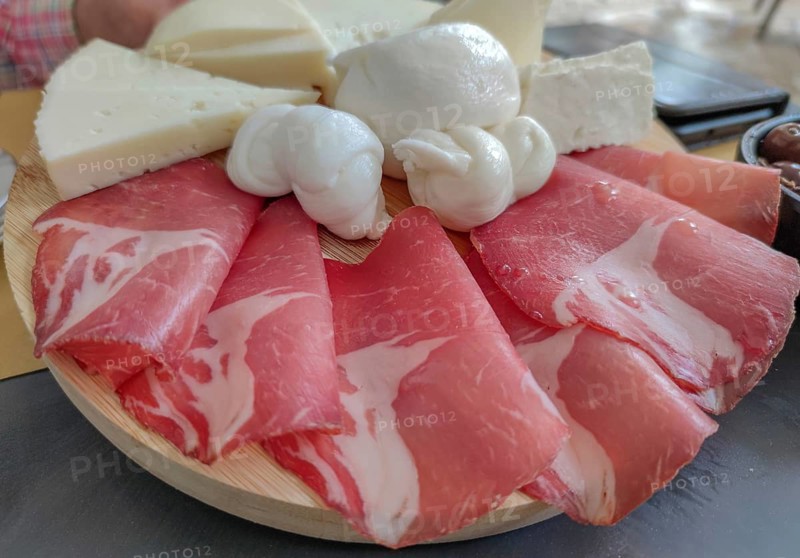 A selection of ham and cheese, arranged on a wooden platter, with buffalo mozzarella in the centre, Martina Franca, Apulia, Italy, Europe