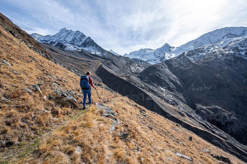 Mountaineer on a hiking trail in Niedertal, snow-covered mountain peaks of the Ötztal Alps with Finailspitze in the background, Ötztal Alps, Tyrol, Austria, Europe