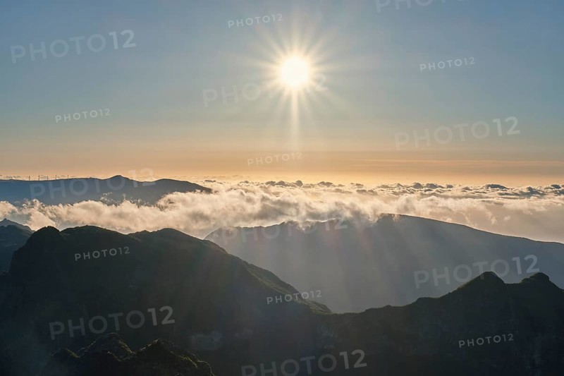 Aerial drone view of mountains over clouds near Pico Ruivo on sunset. Madeira island, Portugal, Europe