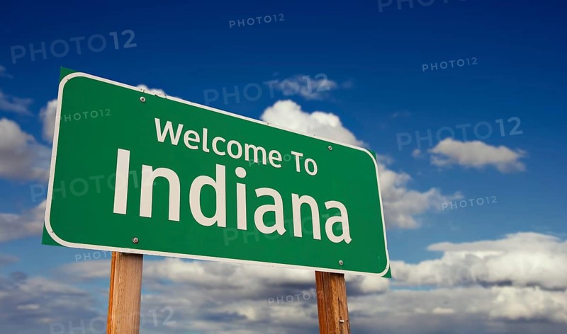 Welcome to Indiana green road sign over blue sky with some clouds