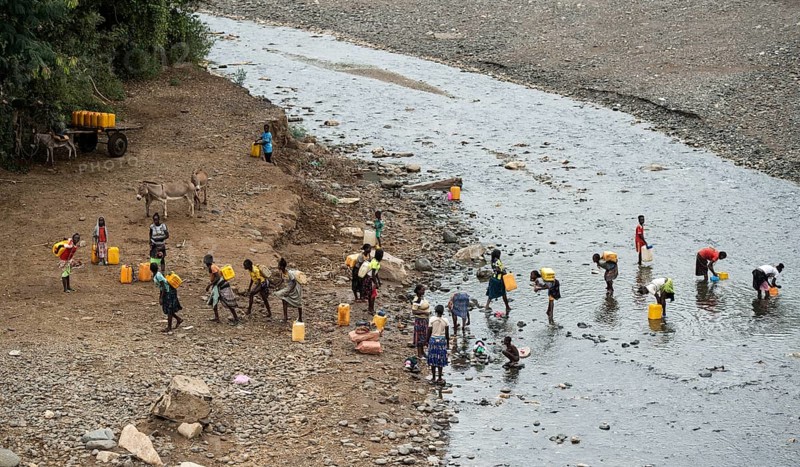 Women and girls fetch water in plastic canisters from a river near the road from Arba Minch to Konso, southern Ethiopia
