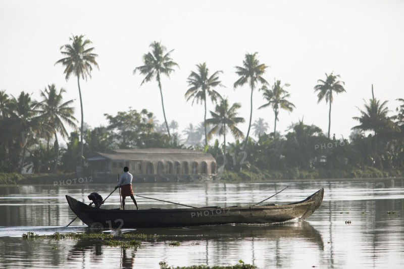 Fisherman in the morning with a boat on the Vembanad Lake, canal system of the backwaters, Kerala, India, Asia