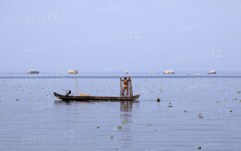 Fisherman on a small boat on the Vembanad Lake, canal system of the backwaters, Kerala, India, Asia