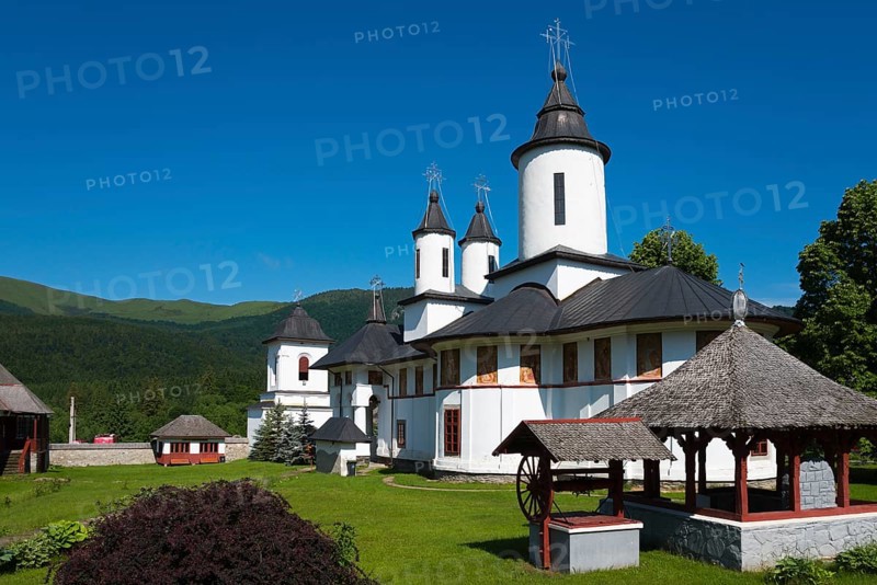 A peaceful Orthodox church with white walls and black roofs in front of a mountain, Cheia Romanian Orthodox Monastery, Maneciu, Maneciu, Prahova, Wallachia, Romania, Europe