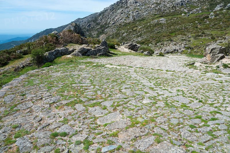 A cobbled path winds through a rocky and green landscape, old Roman road, at the Puerto del Pico, Sierra de Gredos, Ávila, Avila, Castilla y León, Leon, Spain, Europe