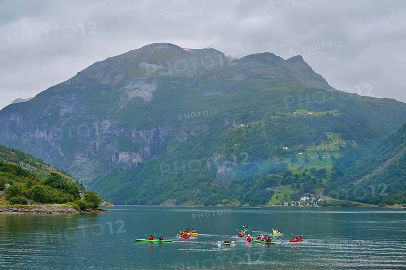 Several kayakers in a fjord surrounded by forested mountains and clouds, Geiranger, Geiranger Fjord, Stranda, Romsdal, Norway, Europe