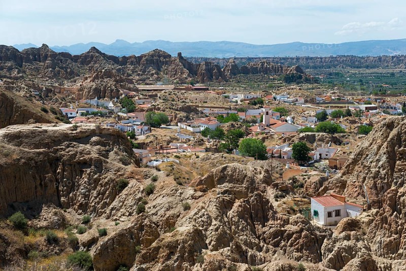 A village of white houses stretches along the rocky and picturesque mountain landscape, view from the Mirador del Cerro de la Bala, cave dwellings, cave neighbourhood, Troglodytos, Barrio de Cuevas, Guadix, Granada province, Andalusia, Spain, Europe