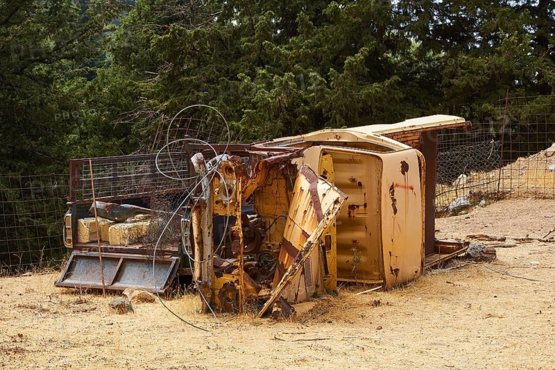 Overturned rusted vehicle in a wooded area, surrounded by twisted metal parts, wrecked vehicle, Crete, Greek Islands, Greece, Europe