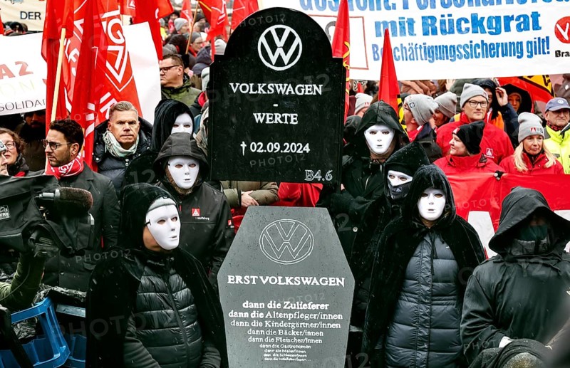 A symbolic VW coffin is carried by Volkswagen employees to the collective bargaining negotiations of Volkswagen and IG Metall in front of the Volkswagen Arena in protest against plant closures and redundancies, Wolfsburg, 21 November 2024, Wolfsburg, Lower Saxony, Germany, Europe