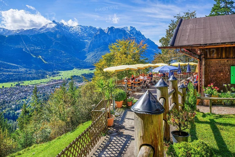 St. Martinshütte with restaurant terrace and view of the valley and Zugspitze group 2962m. Garmisch-Partenkirchen, Loisachtal, Werdenfelser Land, Upper Bavaria, Bavaria, Germany, Europe