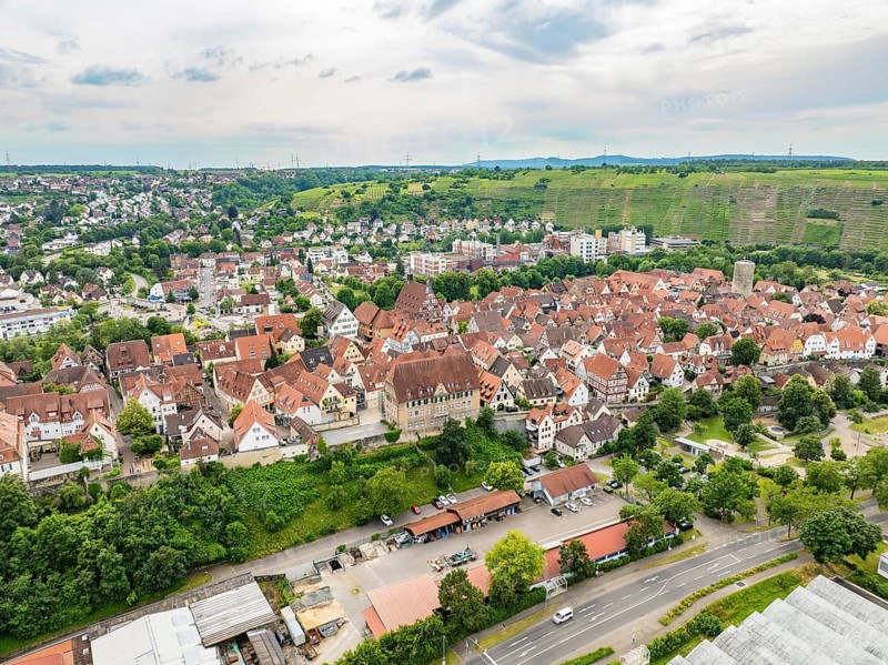 Urban settlement with tightly packed red roofs, surrounded by green hills and crossed by roads, Besigheim, Germany, Europe
