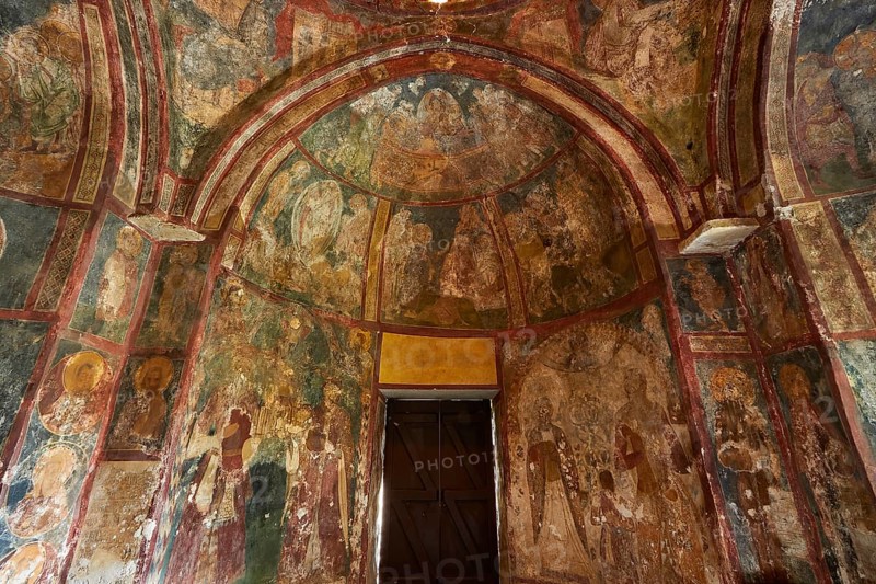 A church interior with frescoes on the walls, religious art and a large wooden door, Byzantine Chapel of Agios Nikolaos Foundoukli, between Eleousa and Profitis Ilias, Rhodes, Dodecanese, Greek Islands, Greece, Europe