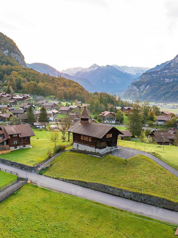 Picturesque Alpine village in a valley surrounded by green hills and majestic mountains, Lake Brienz, Switzerland, Europe