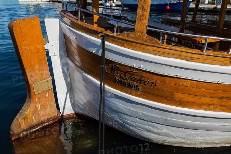 Rudder on docked white painted and varnished wooden boat in harbour in late summer, Sibenik, Croatia, Europe