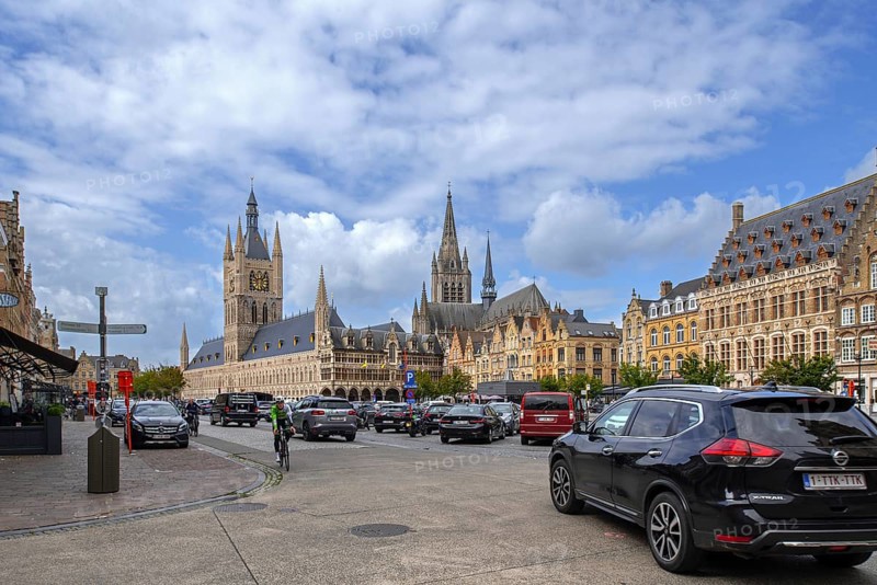 Cloth Hall with belfry and cars parked on the Grand Place at the city Ypres, Ieper, West Flanders, Belgium, Europe