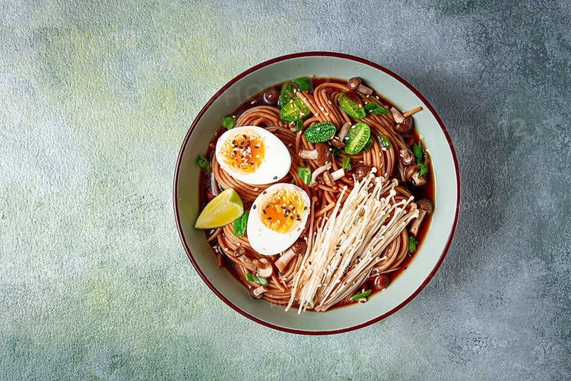 Soba, buckwheat noodles, with enoki mushrooms, shimeji and boiled egg, top view, homemade, no people