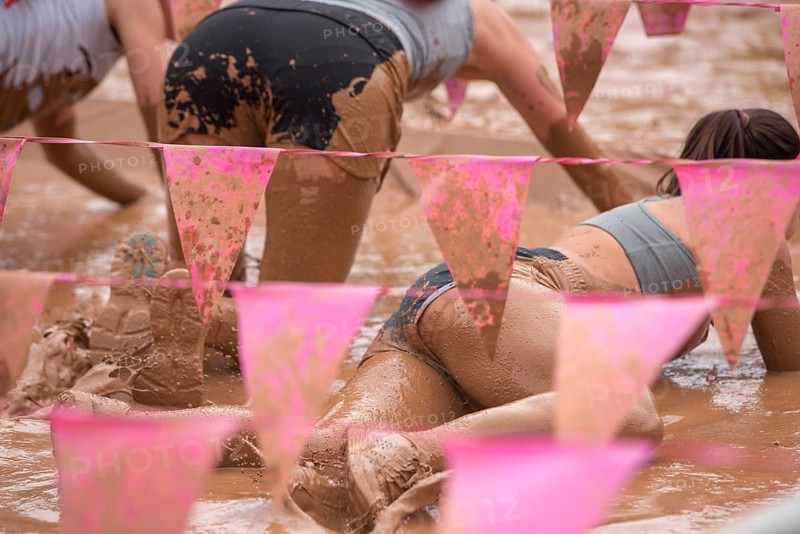 Group of participants in a muddy outdoor obstacle course