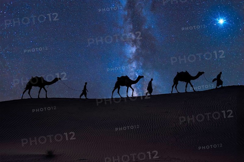 Christmas Jesus birth concept - Adoration of the Magi, Three Wise Men, Three Kings, and the Three biblical Magi with camel silhouettes journeying in sand dunes of desert follow Bethlehem star at night