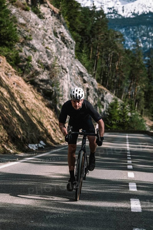 Road bike rider in spring between Lechtal and Tannheimer Tal in front of picturesque scenery of the Alps, Tyrol, Austria, Europe