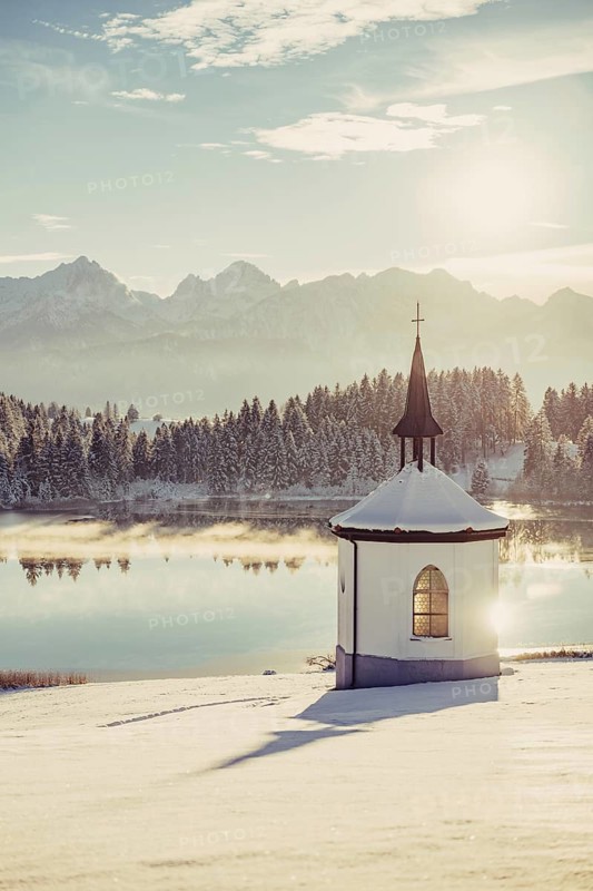 Chapel by the lake in the wintry snow-covered Allgäu near Halblech in front of an impressive mountain landscape, Bavaria, Germany, Europe