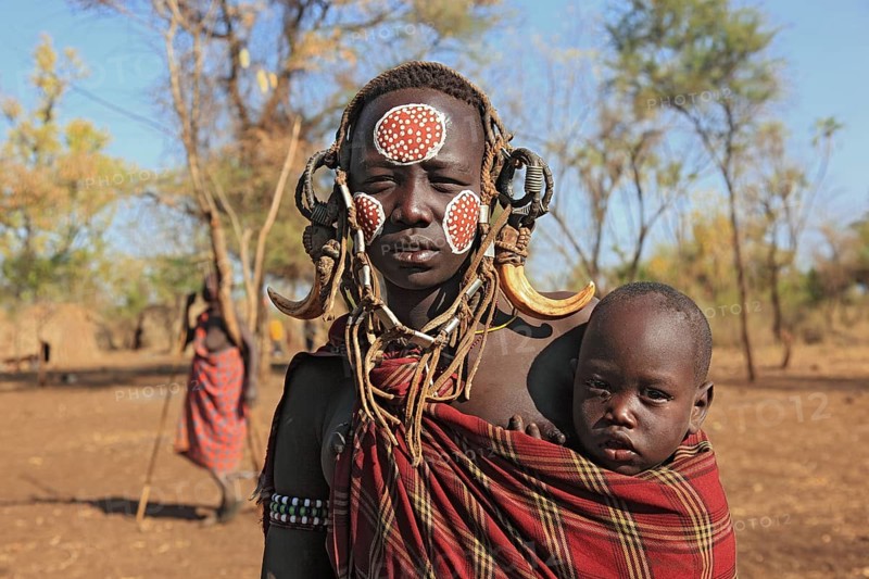 South Ethiopia, in Maco National Park, Mursi tribe, Mursi woman with baby, painted skin and headdress, Ethiopia, Africa