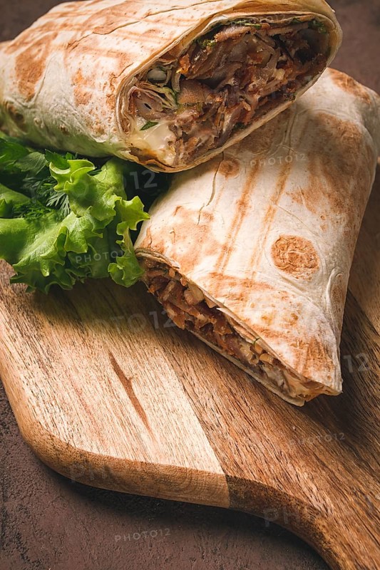 Cut shawarma, 2 pieces, on a cutting board, close-up