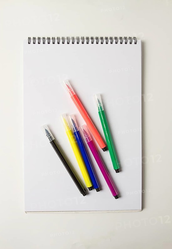 Watercolor pens brush, assortment, on a drawing album, artist's desk, top view, close-up, selective focus