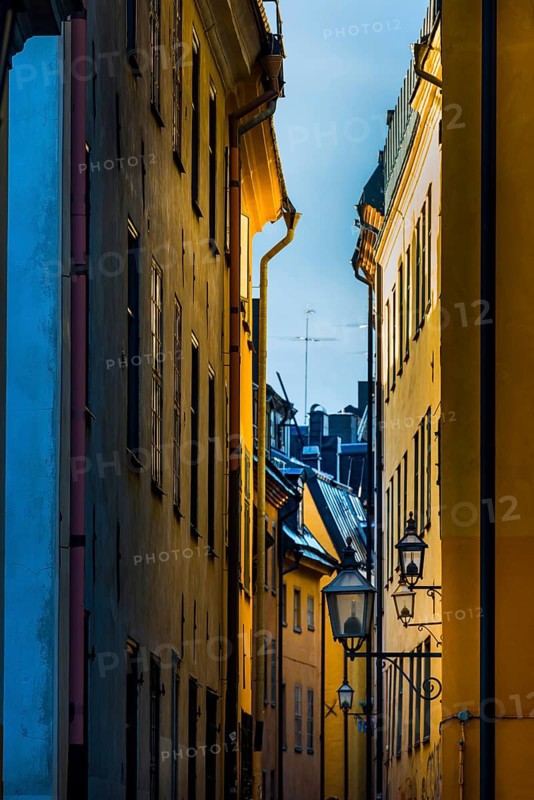Houses in an alley of Gamla Stan, old town, centre, attraction, famous, downtown, city trip, tourism, travel, holiday, architecture, historical, UNESCO, world heritage, yellow, ochre, colour, colourful, painting, evening, culture, history, city history, medieval, urban, Stockholm, Sweden, Scandinavia, Europe