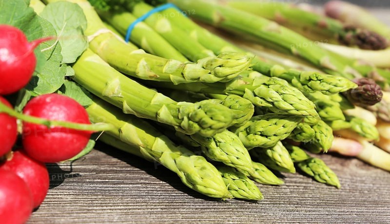 Green asparagus and white asparagus decorated on a rustic wooden table