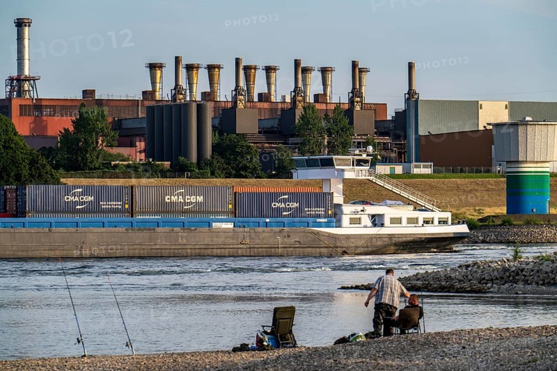 Industrial backdrop of the ThyssenKrupp Steel steelworks in Bruckhausen, on the Rhine, anglers in a bay in the Rhine near Duisburg Bärl, Duisburg, North Rhine-Westphalia, Germany, Europe