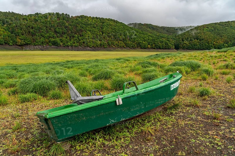 The Edersee, near Waldeck, the third largest reservoir in Germany, currently has only just under 13% of its normal level, the lake was last full in May 2022, dried up due to lack of rain, stranded fishing boat, pike hunter, the lake shore and the lake bottom is overgrown with fresh grass, Hesse, Germany, Europe