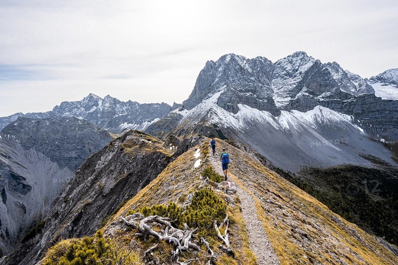 Two mountaineers on a hiking trail on the ridge of Hahnkampl, mountain panorama with rocky steep peaks, view of summit Lamsenspitze, Karwendel Mountains, Alpenpark Karwendel, Tyrol, Austria, Europe