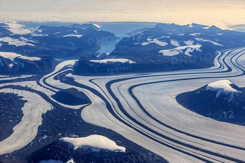 Aerial view of glaciers, glacier tongues and icy mountains on the coast, sunny, East Greenland, Greenland, North America