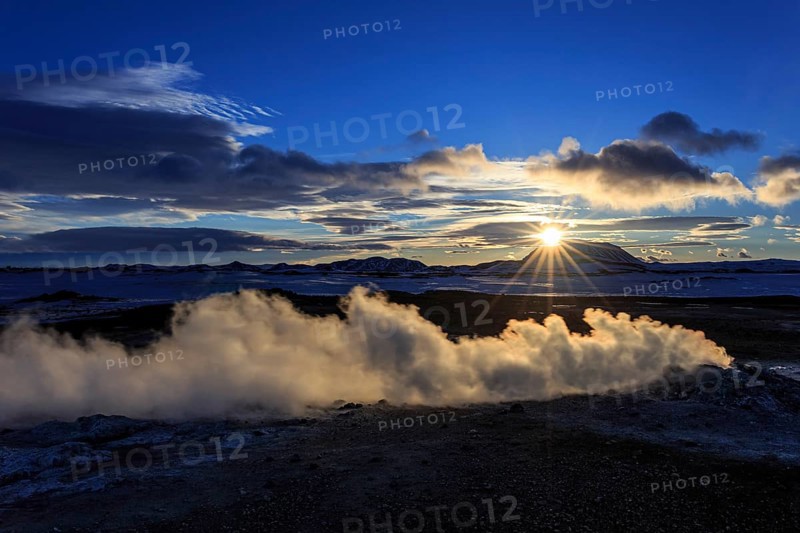 Hot springs and geothermal area in front of mountain landscape in winter, sunbeams, cloudy mood, Hverir, Namafjall, Myvatn, Iceland, Europe