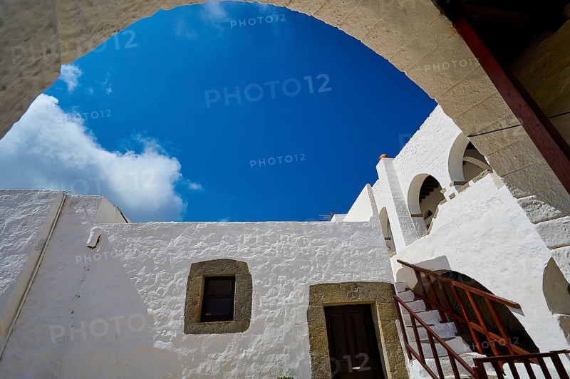 View from below of white buildings and a staircase under an arch in the Greek monastery, Inside the monastery, Agiou Theologou Monastery, Chora, Patmos, Dodecanese, Greek Islands, Greece, Europe