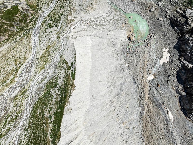 Stream flowing from a glacial lake breaks through a large moraine, valley Val Ferret, aerial view, Valais, Wallis, Switzerland, Europe