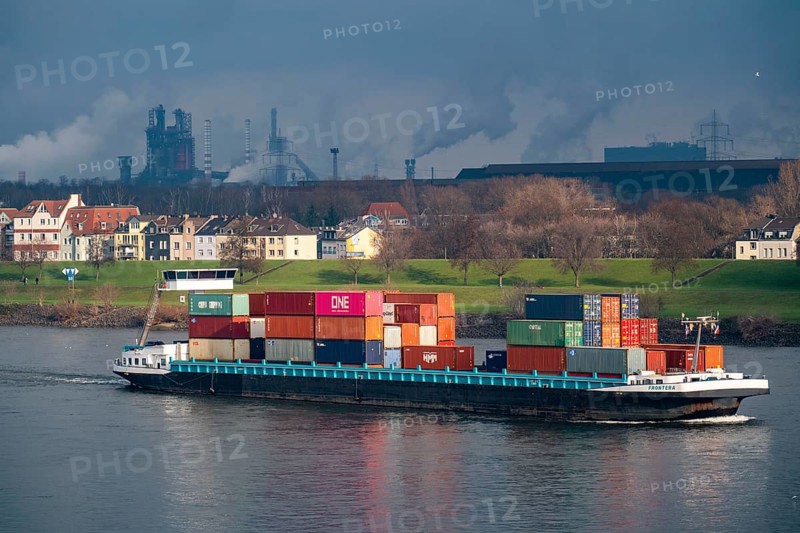 The river Rhine near Duisburg, houses on the Rhine dyke, Laar district, Thyssenkrupp Steel steelworks in Bruckhausen, cargo ship, Duisburg, North Rhine-Westphalia, Germany, Europe