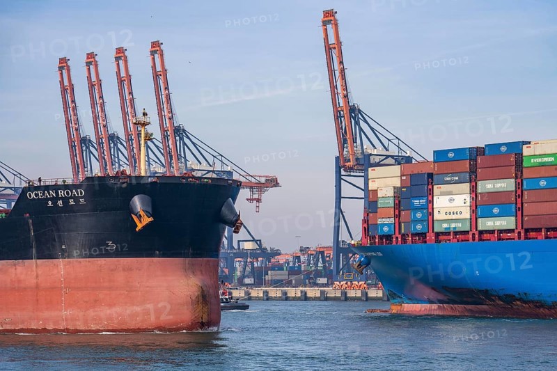 Harbour tugs bring the container freighter Cosco Shipping Leo to its berth at Hutchison Ports ECT Euromax, at the Yangtzekanaal on Maasvlakte 2, bulk freighter Ocean Road leaves the harbour basin, Rotterdam, Netherlands