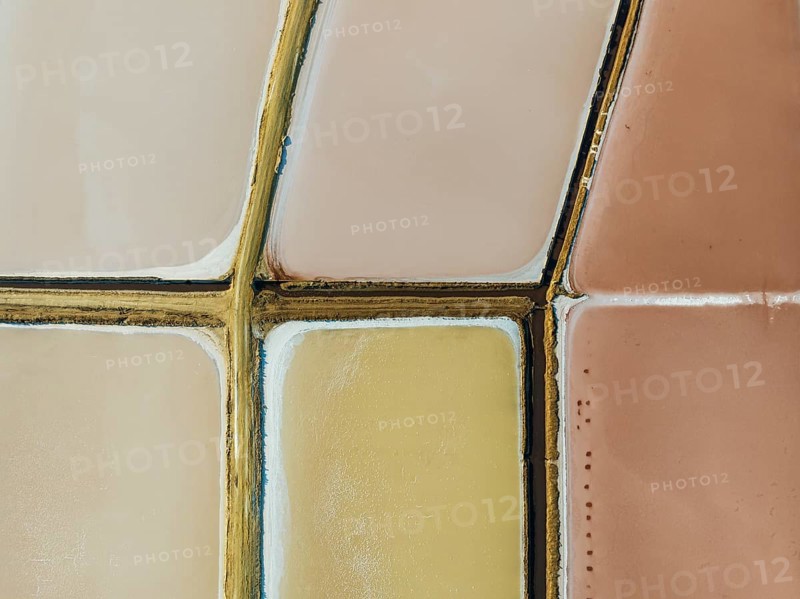 Saline ponds at the Bonanza salt works near Sanlúcar de Barrameda. The reddish colour depends on the level of salinity and is directly caused by the algae Dunaliella salina and brine shrimp. Aerial view. Drone shot. Cádiz province, Andalusia, Spain, Europe