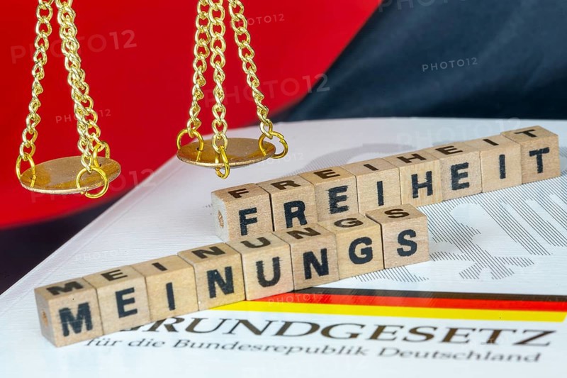Symbolic image of freedom of opinion in Germany: The word FREEDOM OF OPINION in letter cubes next to the scales of Justice and the Basic Law