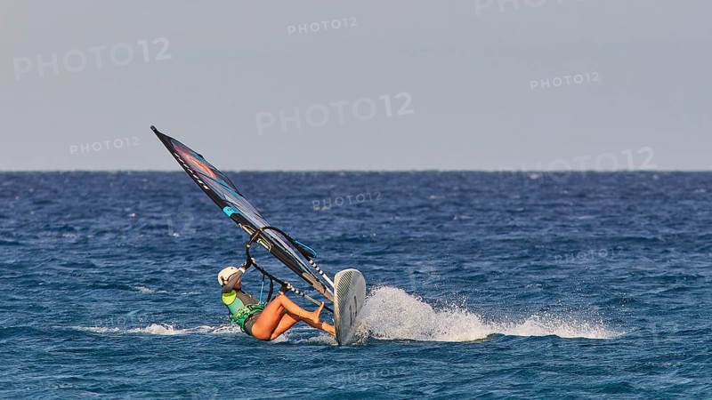 Person in green t-shirt balancing on a wave with a windsurfing board, windsurfer, Meltemi windsurfing spot, Devils Bay, Paralia Vatha, Vatha Beach, Southeast coast, Karpathos, Dodecanese, Greek Islands, Greece, Europe