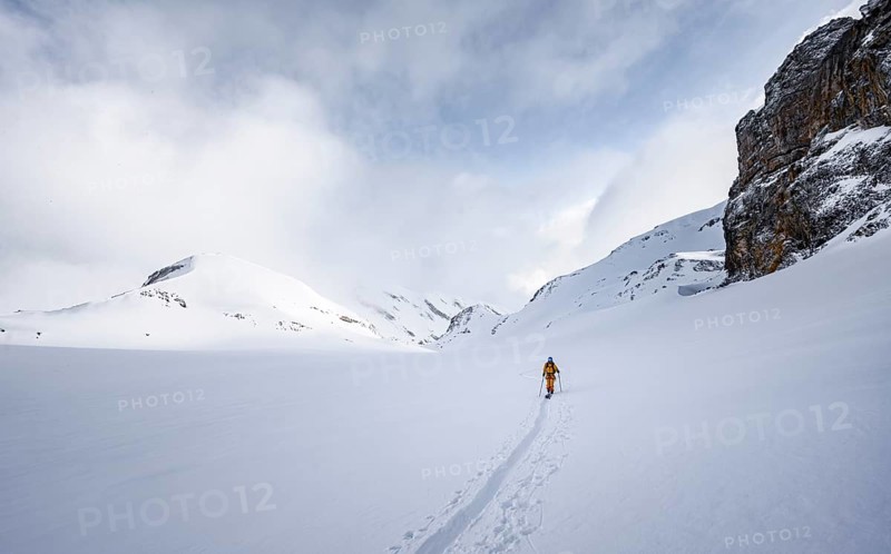 Lone ski tourer in snowy mountain landscape in the morning light, ascent to the Wildhorn, cloudy mood, high tour, Bernese Alps, Bernese Oberland, Switzerland, Europe