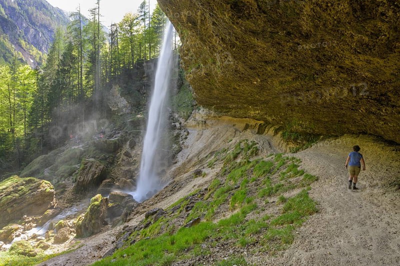 Woman walking behind the cascade of the Pericnik waterfall, Mojstrana, Kranjska Gora, Slovenia, Europe