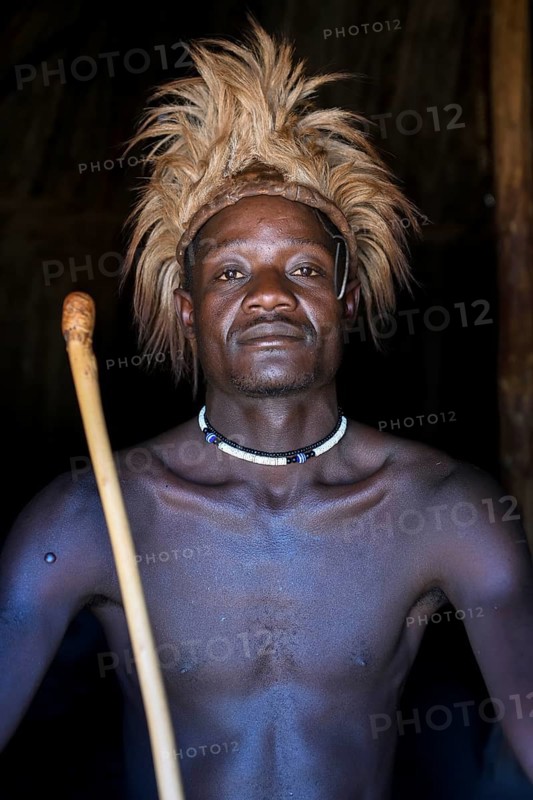 Young Himba man in his hut, Ohandungu, Kunene region, Kaokoveld, Namibia, Africa
