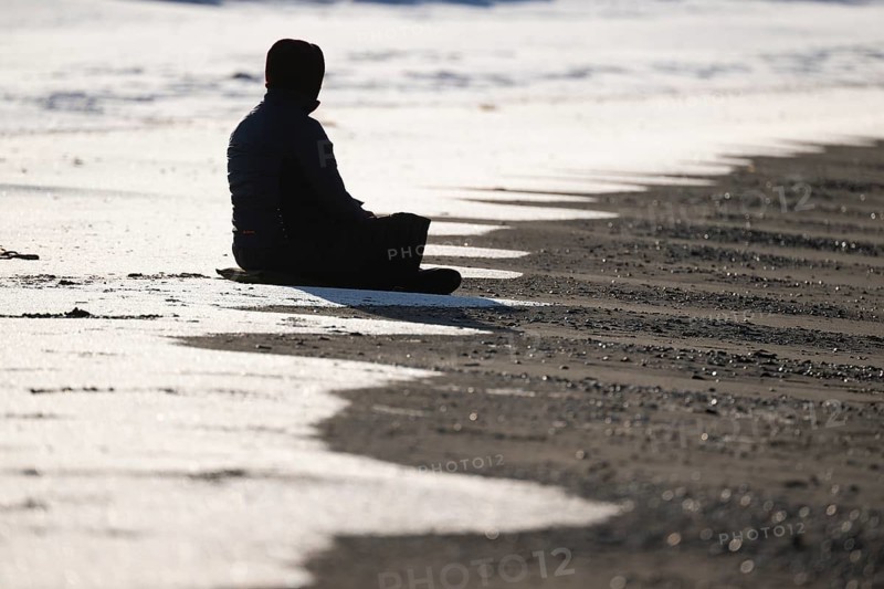Meditating woman, snowy beach, Spitsbergen Island, Svalbard and Jan Mayen archipelago, Norway, Europe