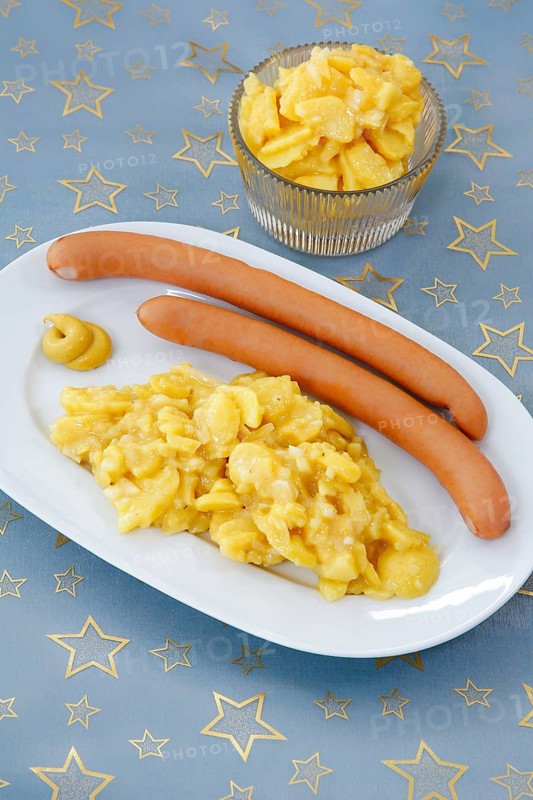 Swabian cuisine, potato salad with string sausages, Wienerle, Wiener sausages, thin boiled sausage, horseradish sausage, Frankfurter sausage, savoury, salty, typical Swabian, typical Christmas dinner, quick cuisine for Christmas Eve, home cooking, traditional cuisine, Christmas table setting, table linen with golden stars, serving platter, mustard, food photography, studio, Germany, Europe