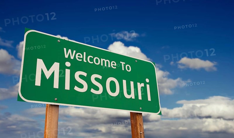 Welcome to missouri green road sign over blue sky with some clouds