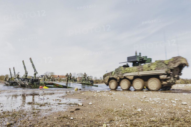 A Pandur II tank navigates the Bundeswehr's Amphibie M3 floating high-speed bridge in the Elbe as part of the military exercise 'Wettiner Schwert' with German and Czech soldiers near Tangermünde, 26 March 2024. 'Wettiner Schwert' is part of the NATO Quadriga exercise