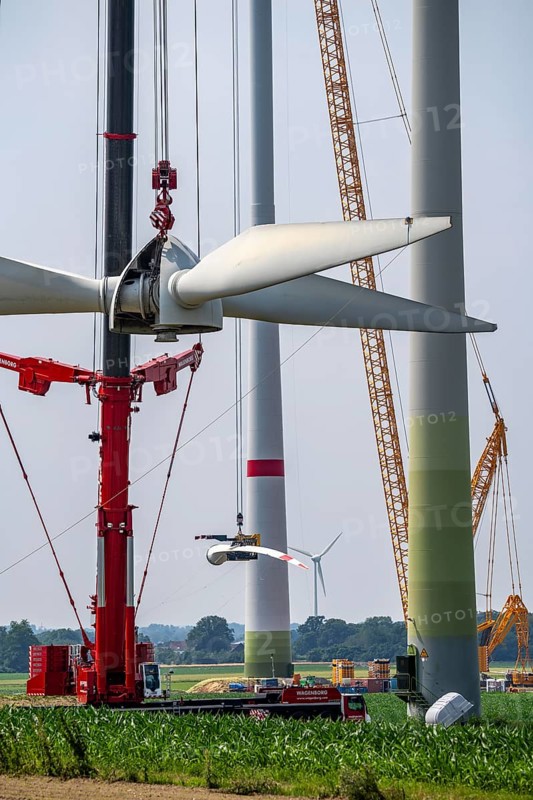 Dismantling of a wind power plant in a wind farm near Issum, 9 older wind turbines from the manufacturer Enercon (model series E-58), front, blades being dismantled, were in operation for over two decades, will be replaced by a total of four Enercon E-160 turbines, rear, assembly of the first blade, with a total output of 22 megawatts, Lower Rhine, North Rhine-Westphalia, Germany, Europe